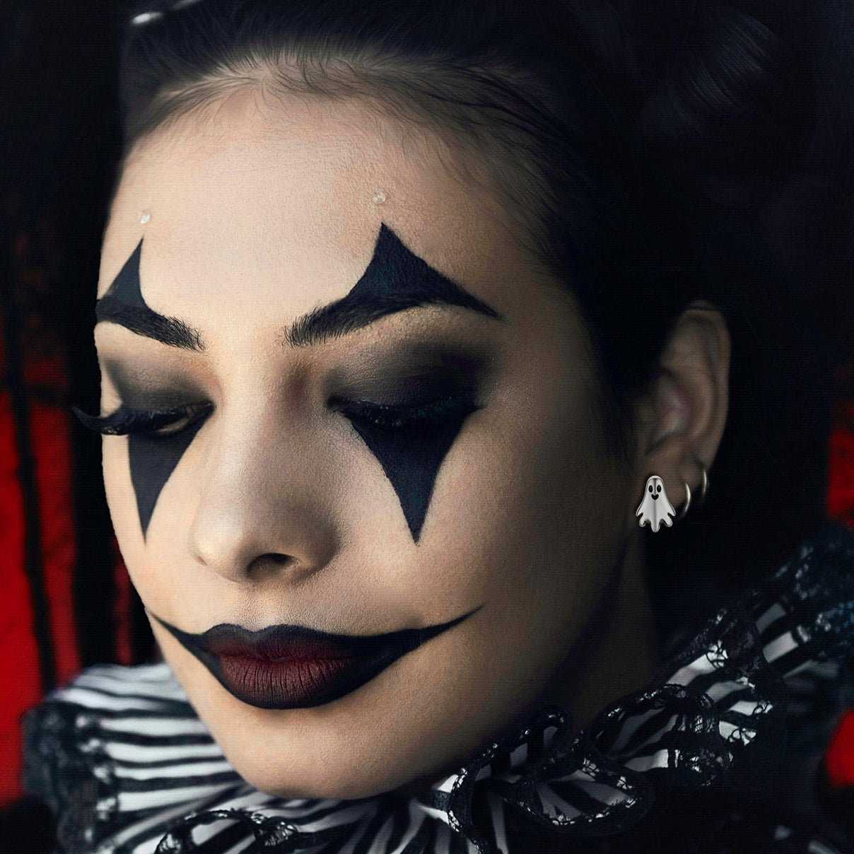 women wearing a ghost earrings and white outfit with dramatic makeup