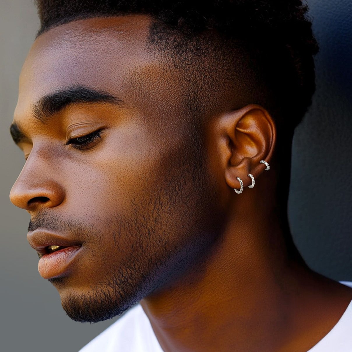 Man wearing small sterling silver huggie hoop earrings