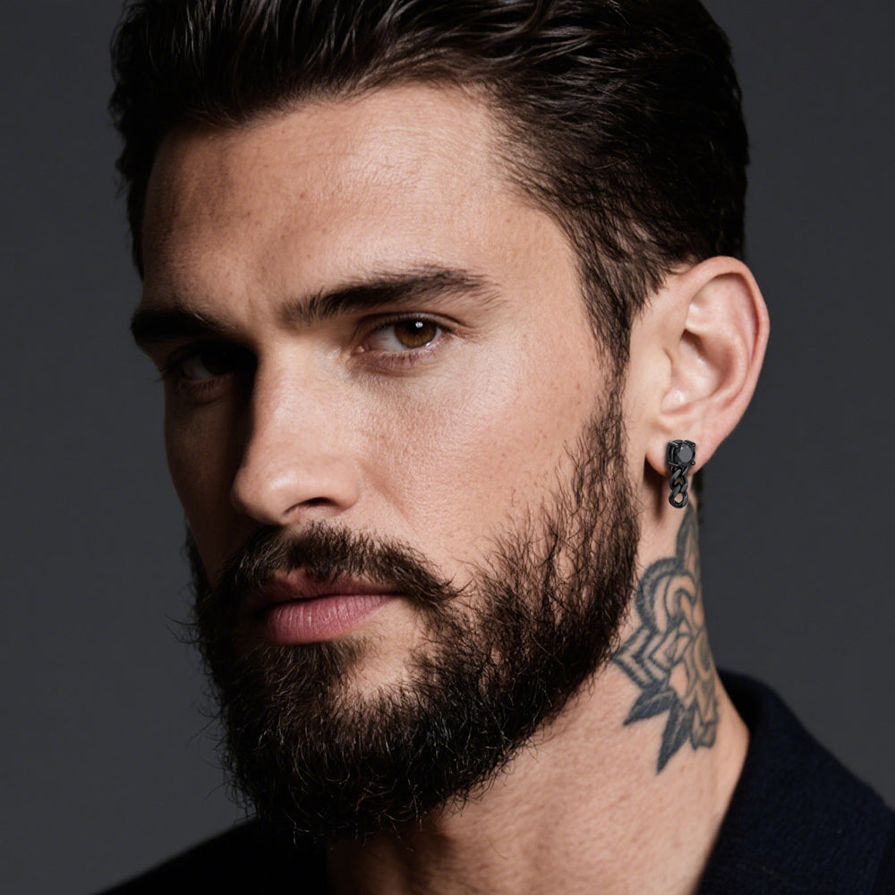 Man with beard and tattoo wearing an earring against a dark background
