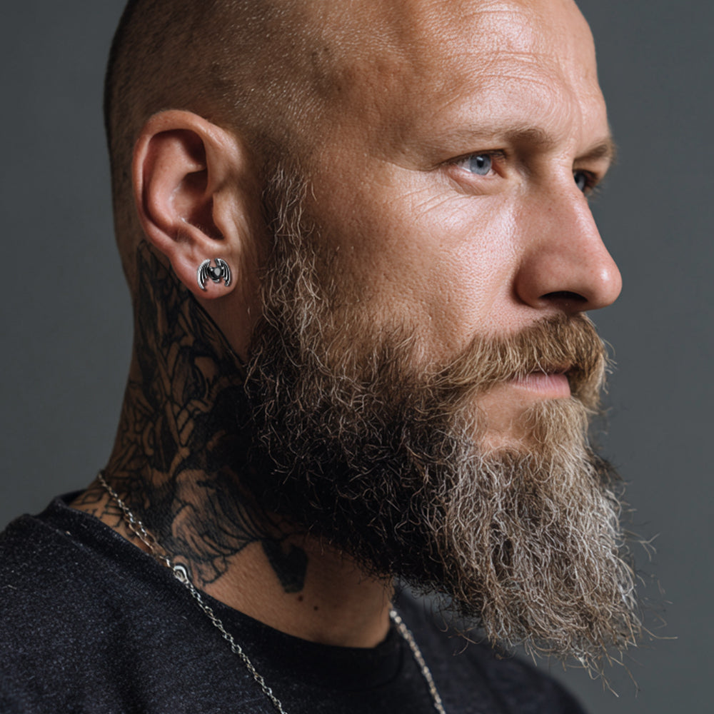 Man with tattoos and a beard on a gray background