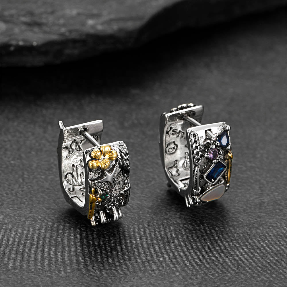 Close-up of graffiti-inspired eagle shield silver earrings with colorful crystal inlays