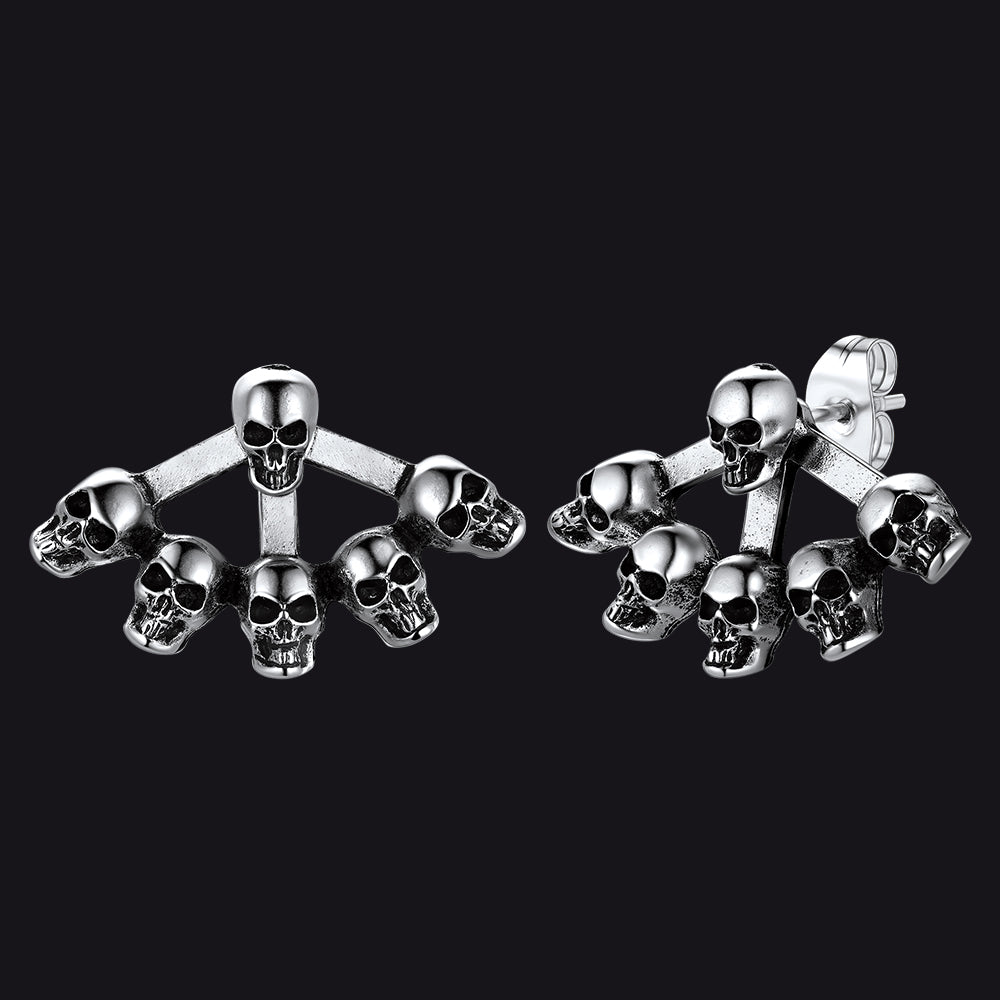 Gothic style skull head stud earrings for men on dark textured background.