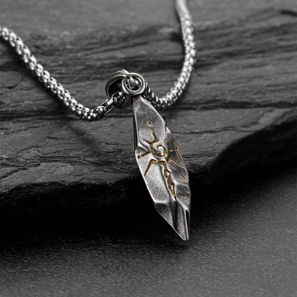 Silver feather pendant necklace on a dark stone surface