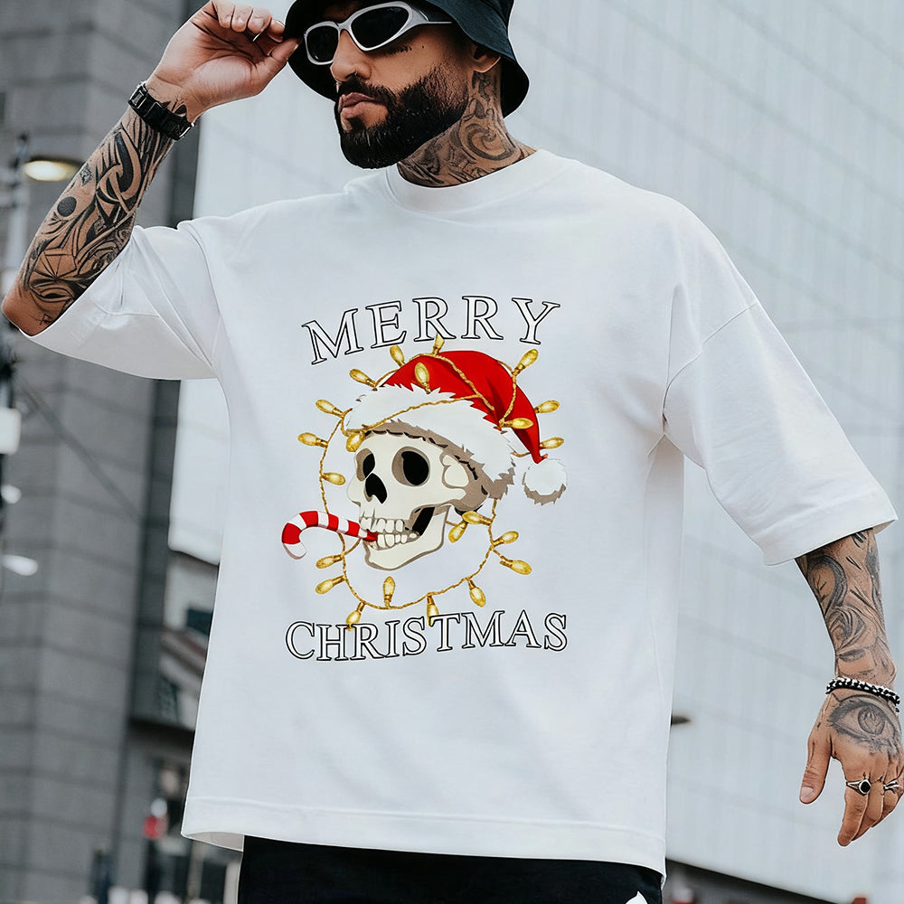 Person wearing a white t-shirt with a skull and Christmas lights design, text 'Merry Christmas'.