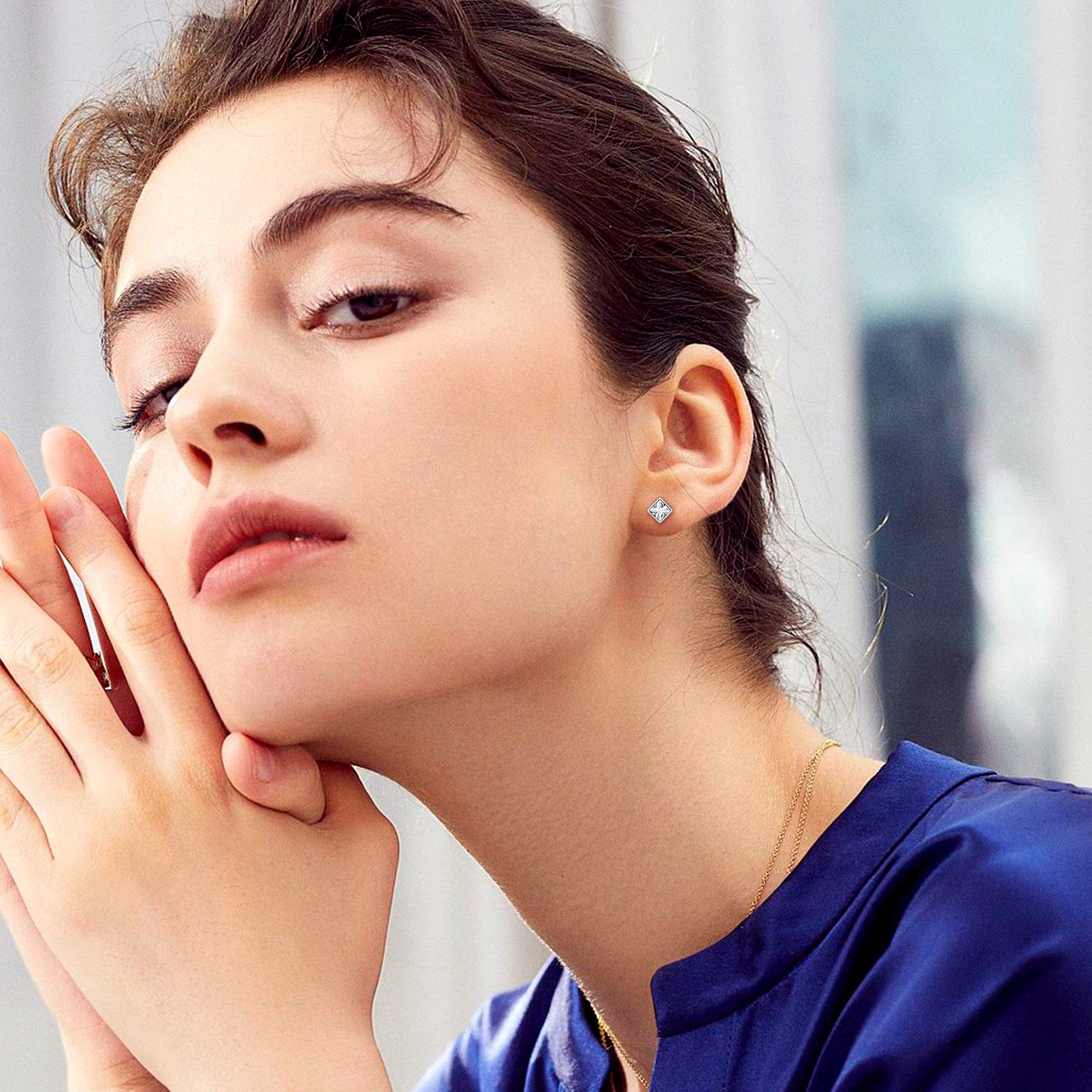 Woman wearing sterling silver square stud earrings