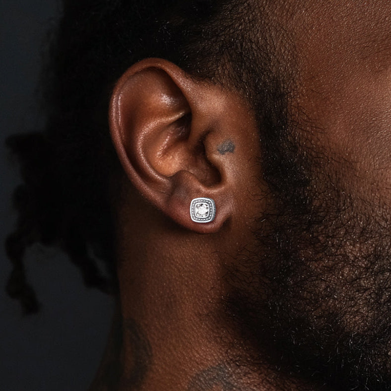 Close-up of a person's ear with an earring against a dark background