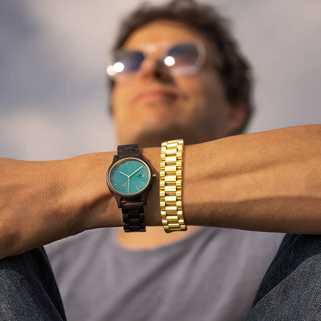 Man wearing watch and gold chunky bracelet