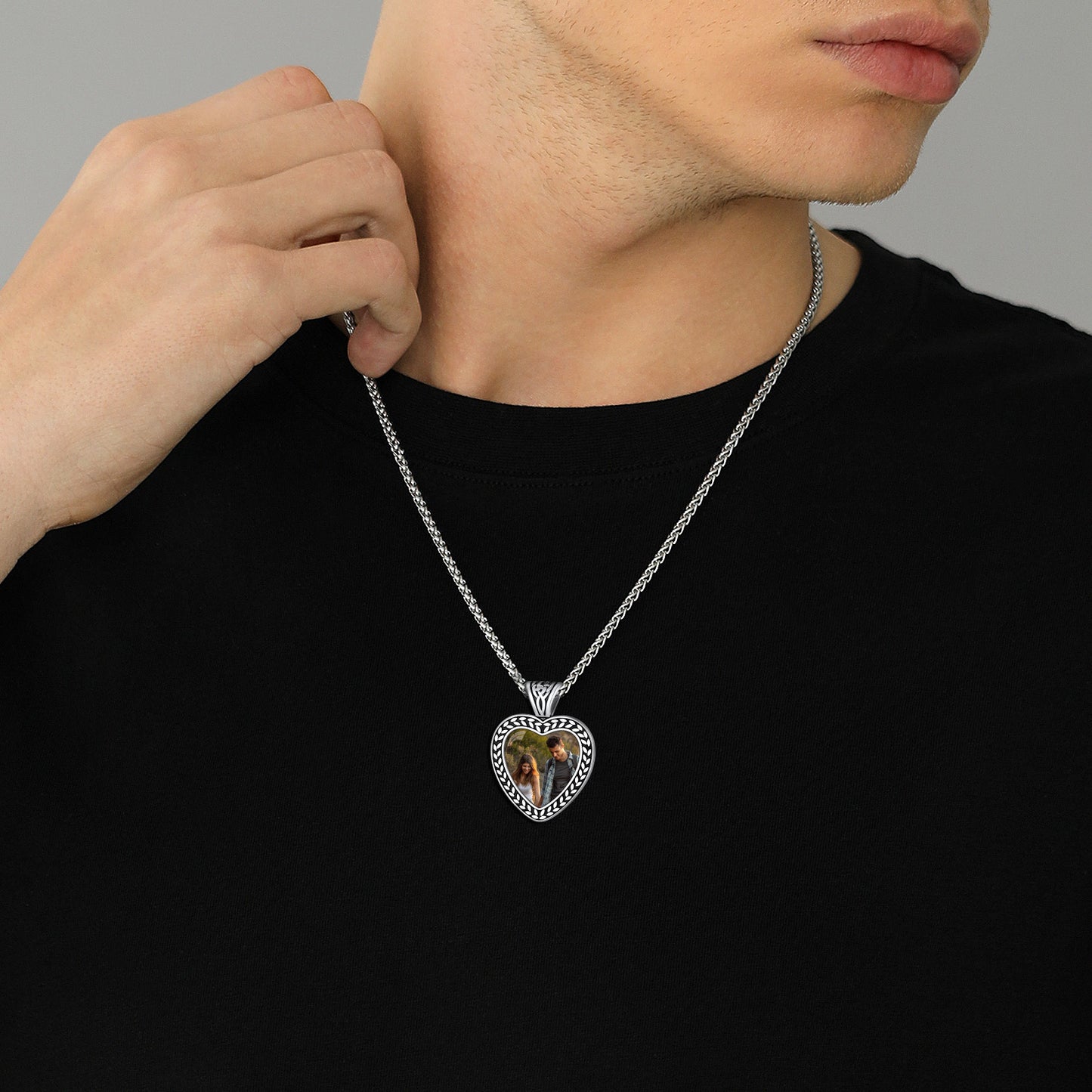 Man wearing heart-shaped photo pendant necklace, stainless steel jewelry