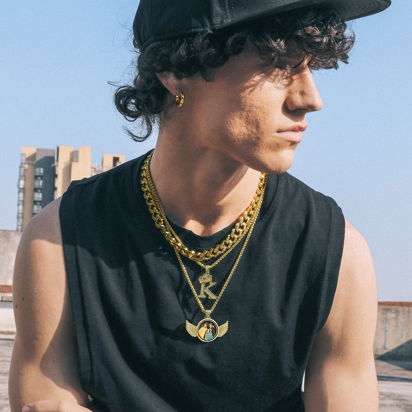 Man wearing Custom angel wing photo necklace with other gold necklaces
