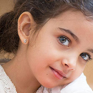 Sterling silver 'S' initial stud earring on a young girl