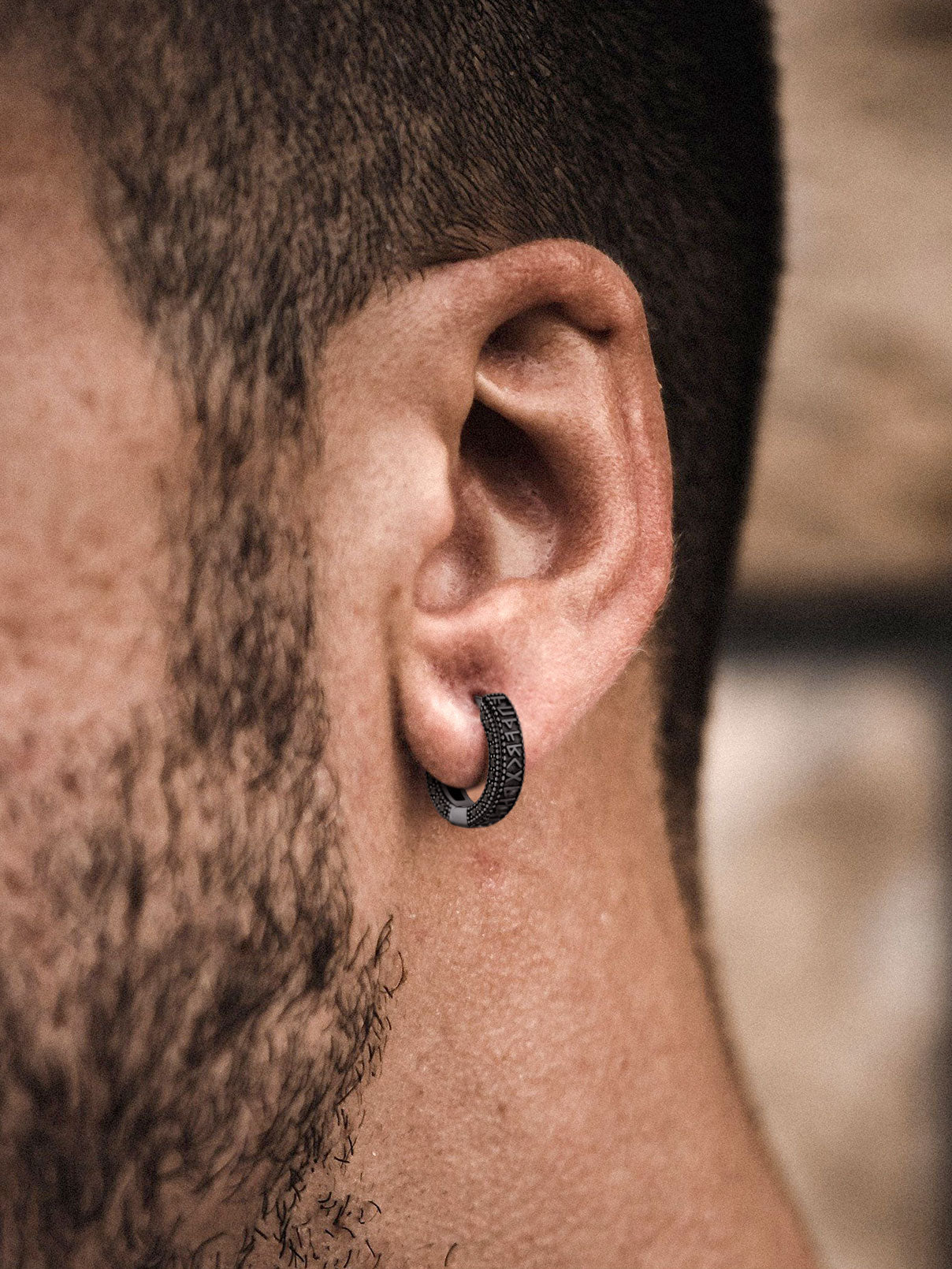 Man wearing black zirconia Viking rune hoop earring