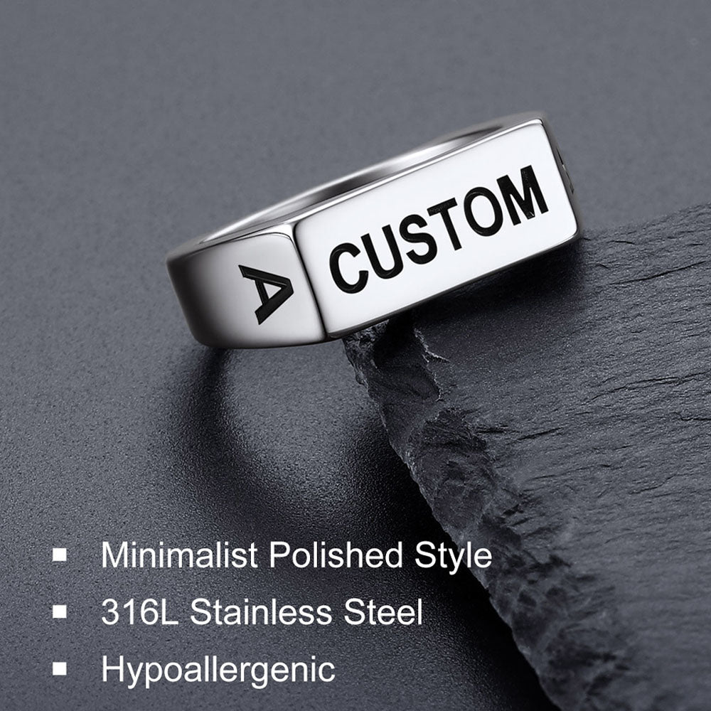 Silver ring with 'CUSTOM' engraving on a dark surface