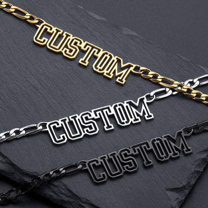 Three gold, silver, and black 'CUSTOM' chain necklaces on a dark surface.