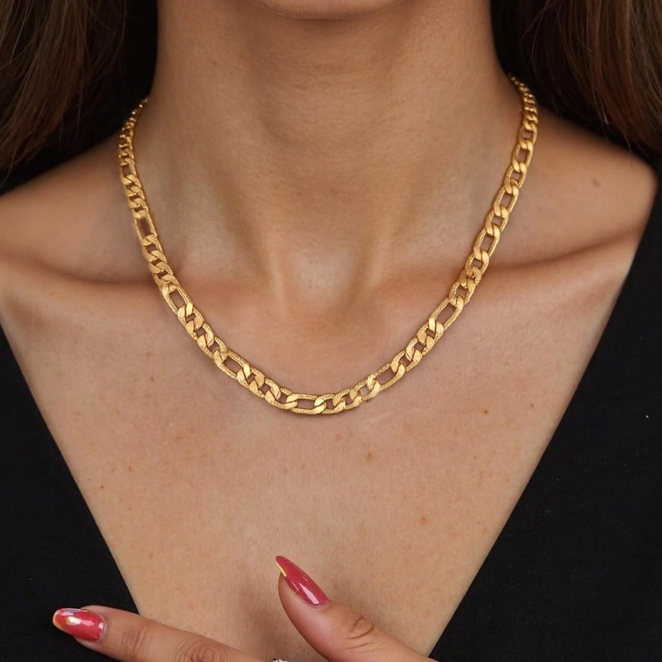 Female model styling gold Figaro link chain with minimal streetwear look
