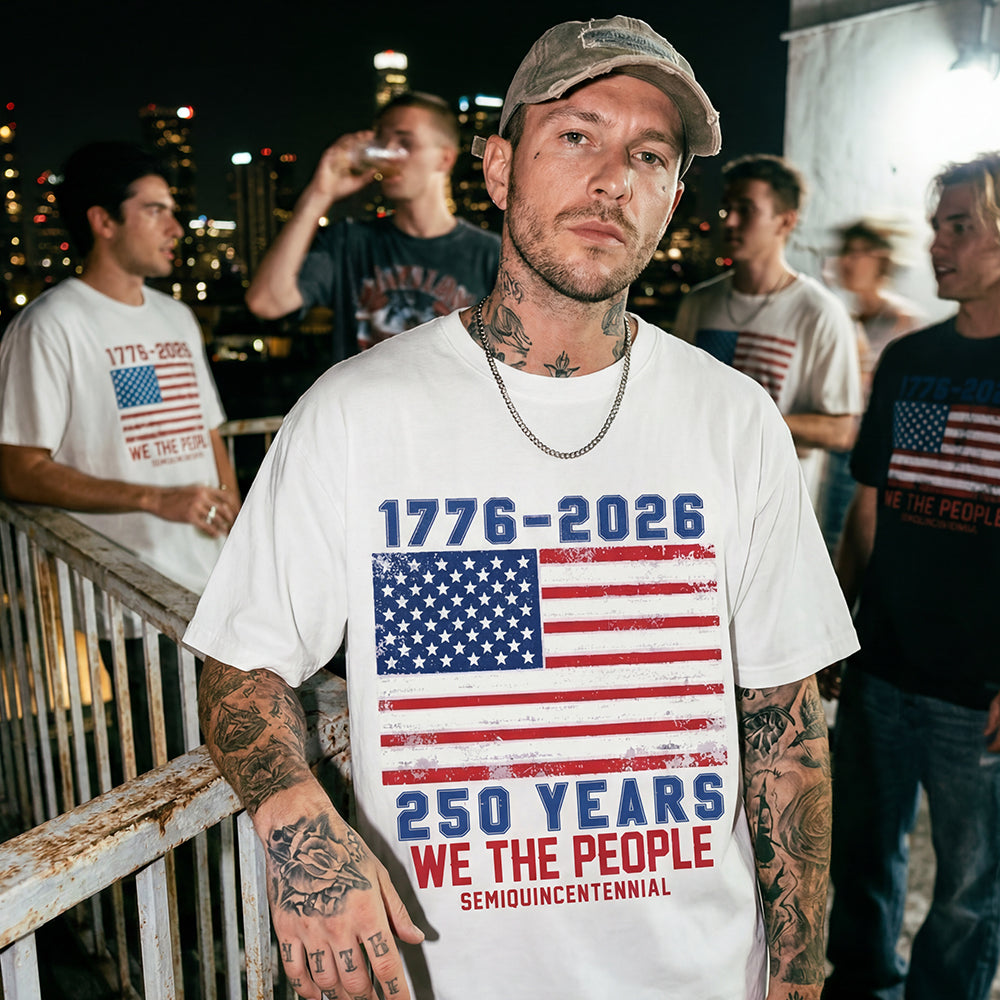 Man wearing a white t-shirt with American flag design and text, standing outdoors at night.