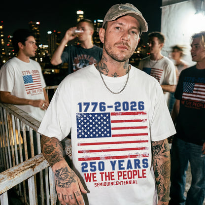 Man wearing a white t-shirt with American flag design and text, standing outdoors at night.