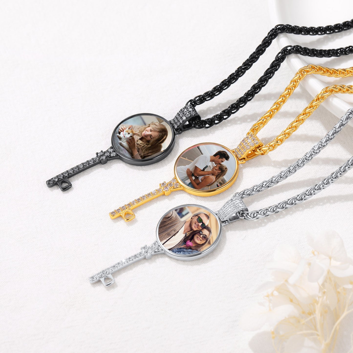 necklaces with round pendants displaying photos of a couple on a white surface.