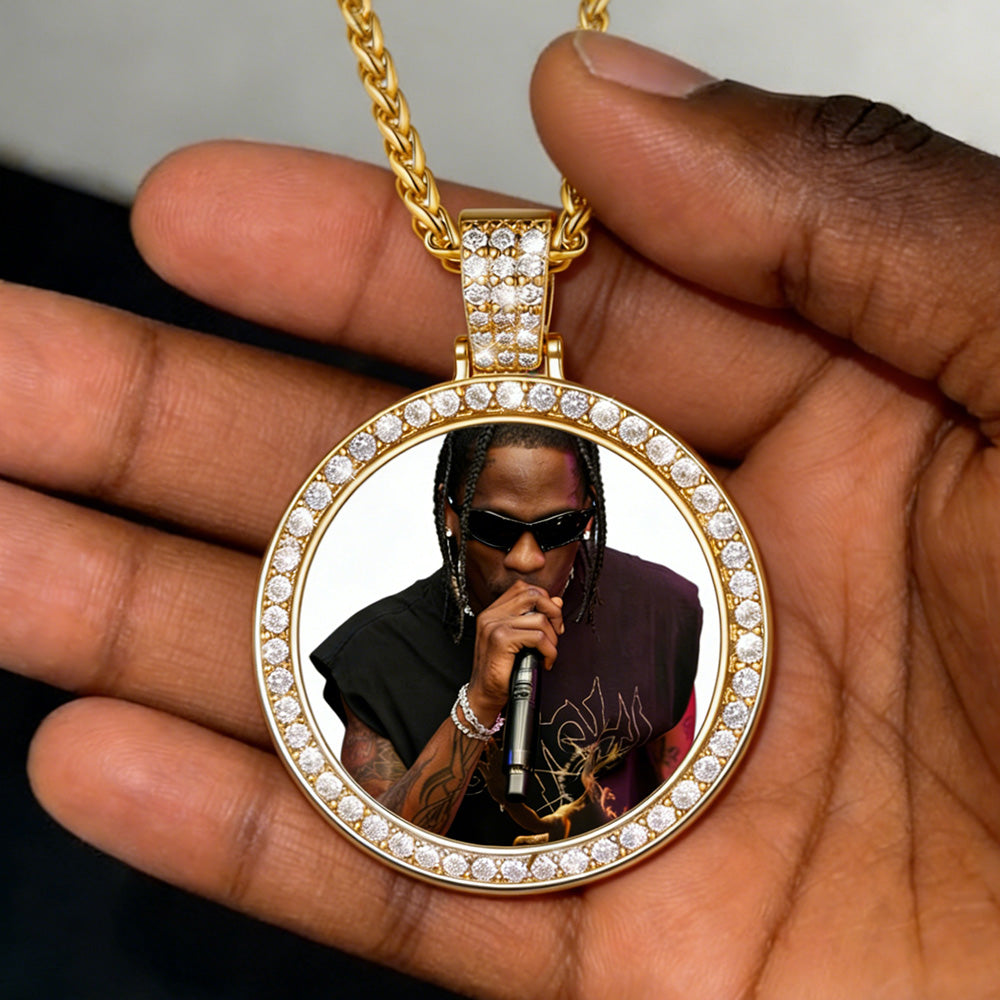 Gold pendant with a person holding a microphone, displayed on a hand.