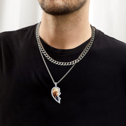 Man wearing a black shirt with a silver chain necklace featuring a pendant.