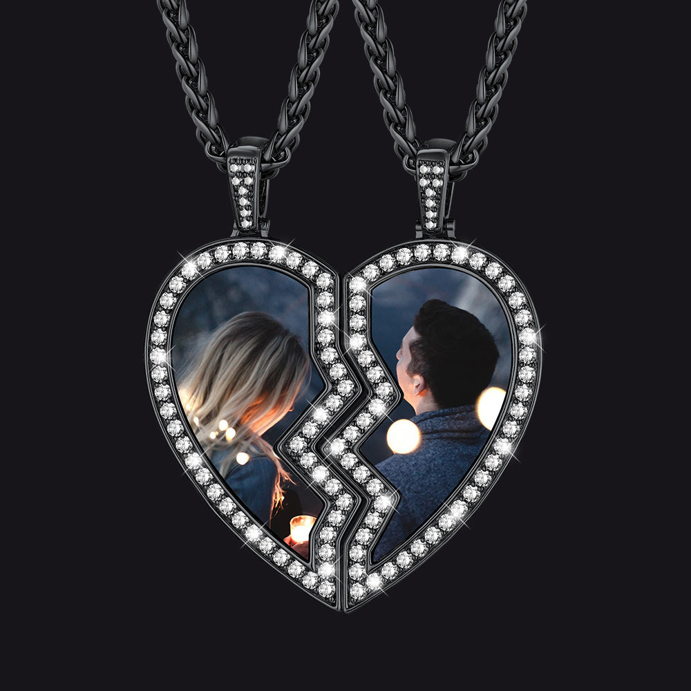 Heart-shaped pendant with two halves, each showing a person, on a black background.