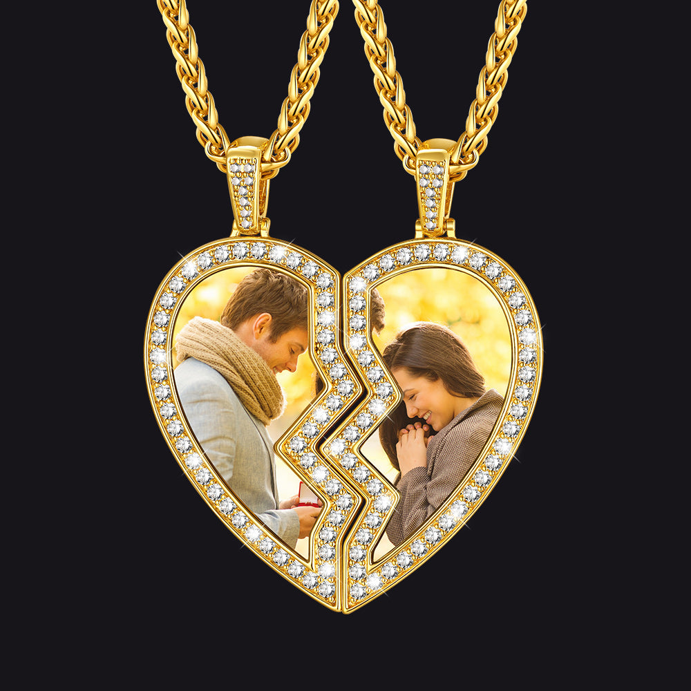 Gold heart-shaped pendant with two halves showing a couple embracing, on a black background.