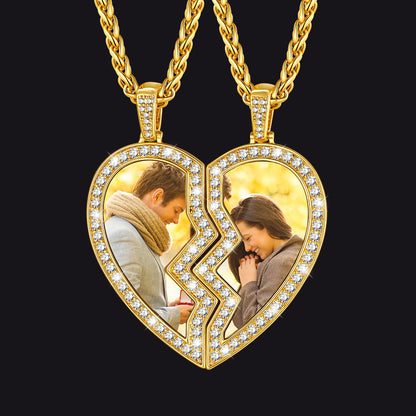 Gold heart-shaped pendant with two halves showing a couple embracing, on a black background.