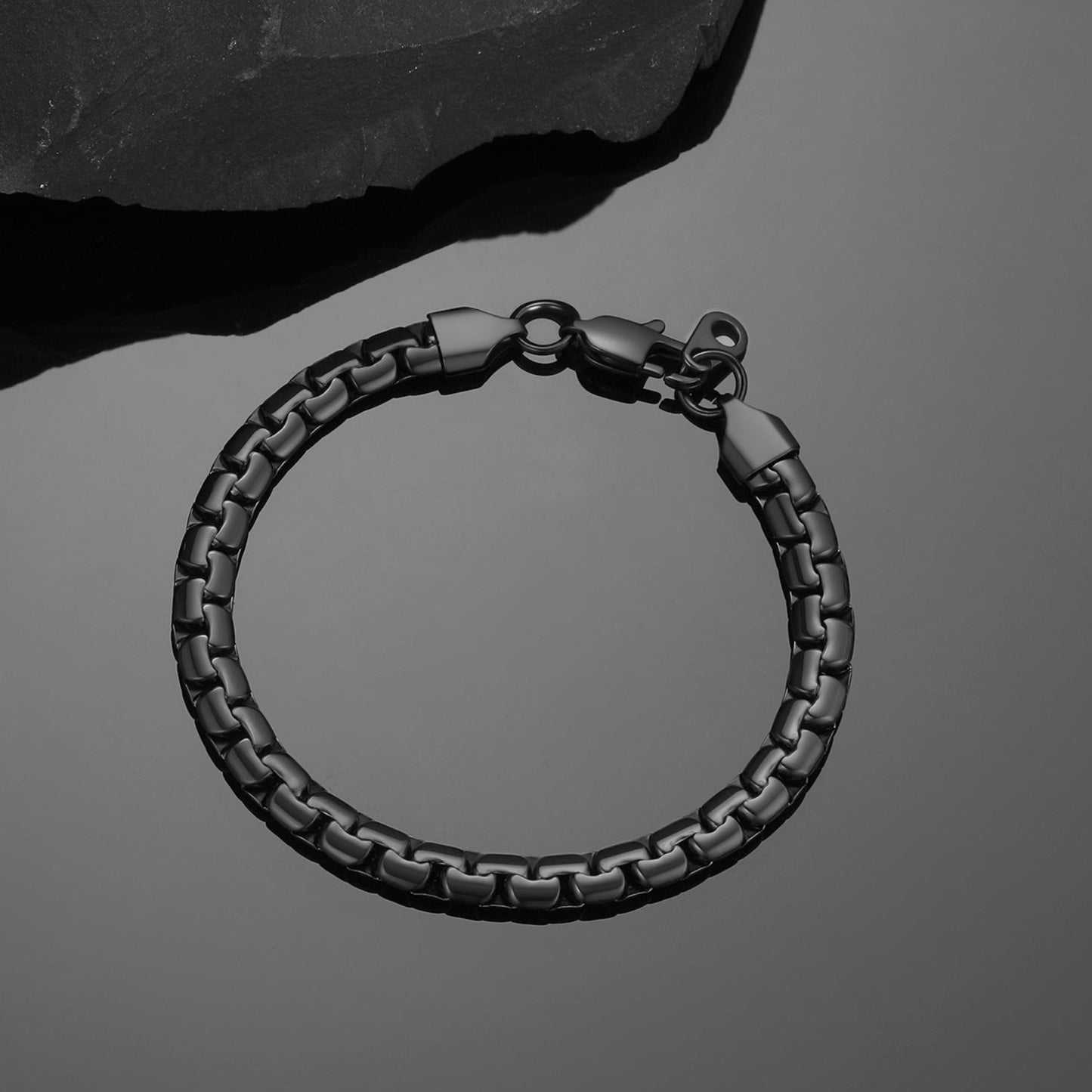 Black braided bracelet on a dark gray background
