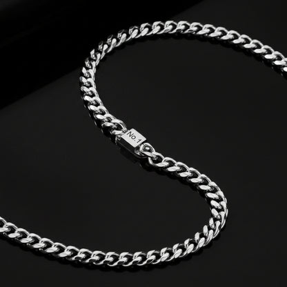 Silver chain necklace on a gray surface