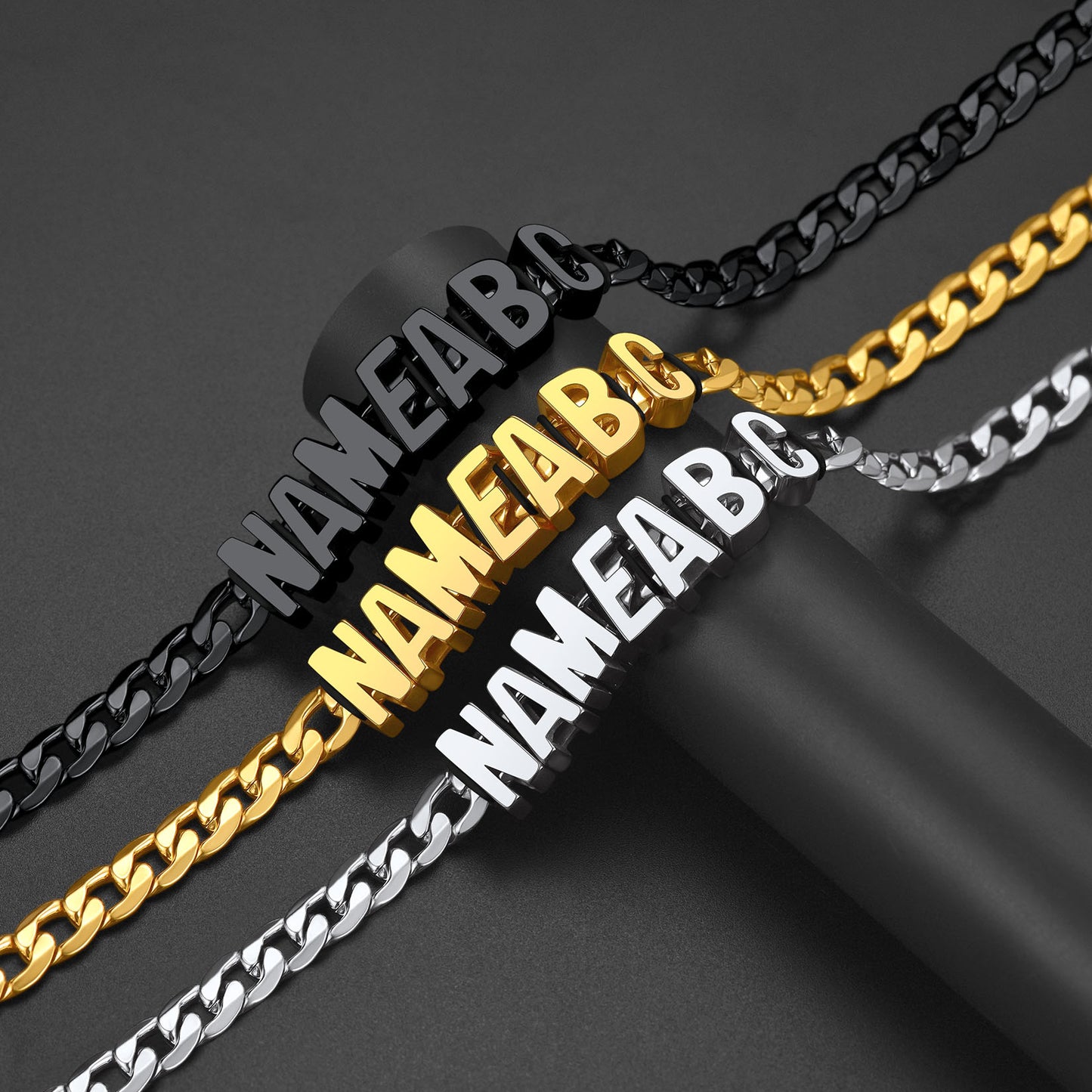 Three chain necklaces in black, gold, and silver with 'NAMEA B C' engraving.