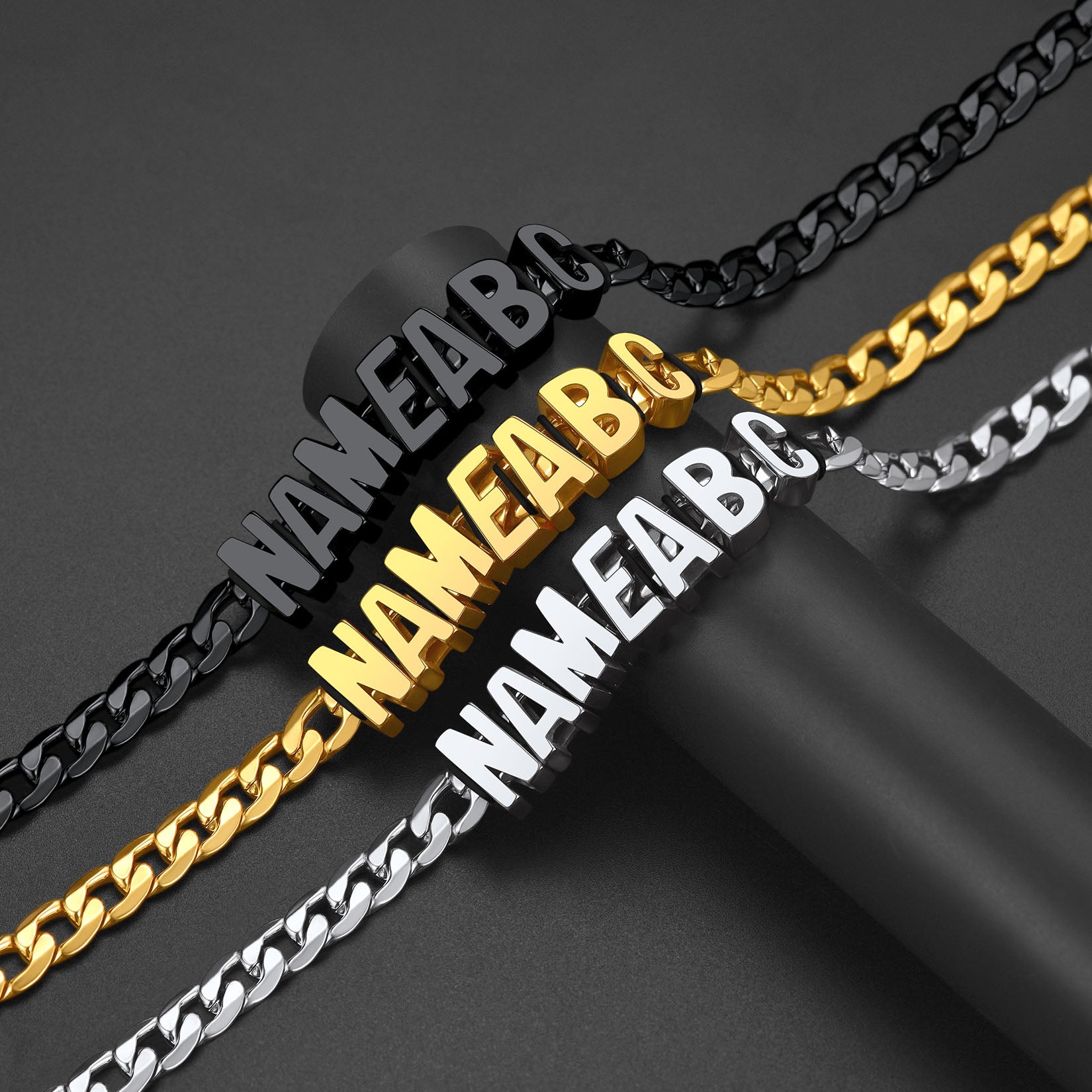 Three chain necklaces in black, gold, and silver with 'NAMEA B C' engraving.