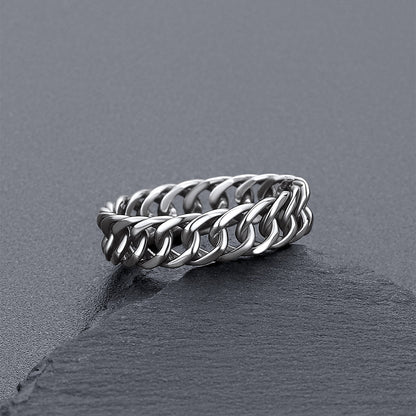 A silver-toned chain-link ring resting on a dark gray slate surface.