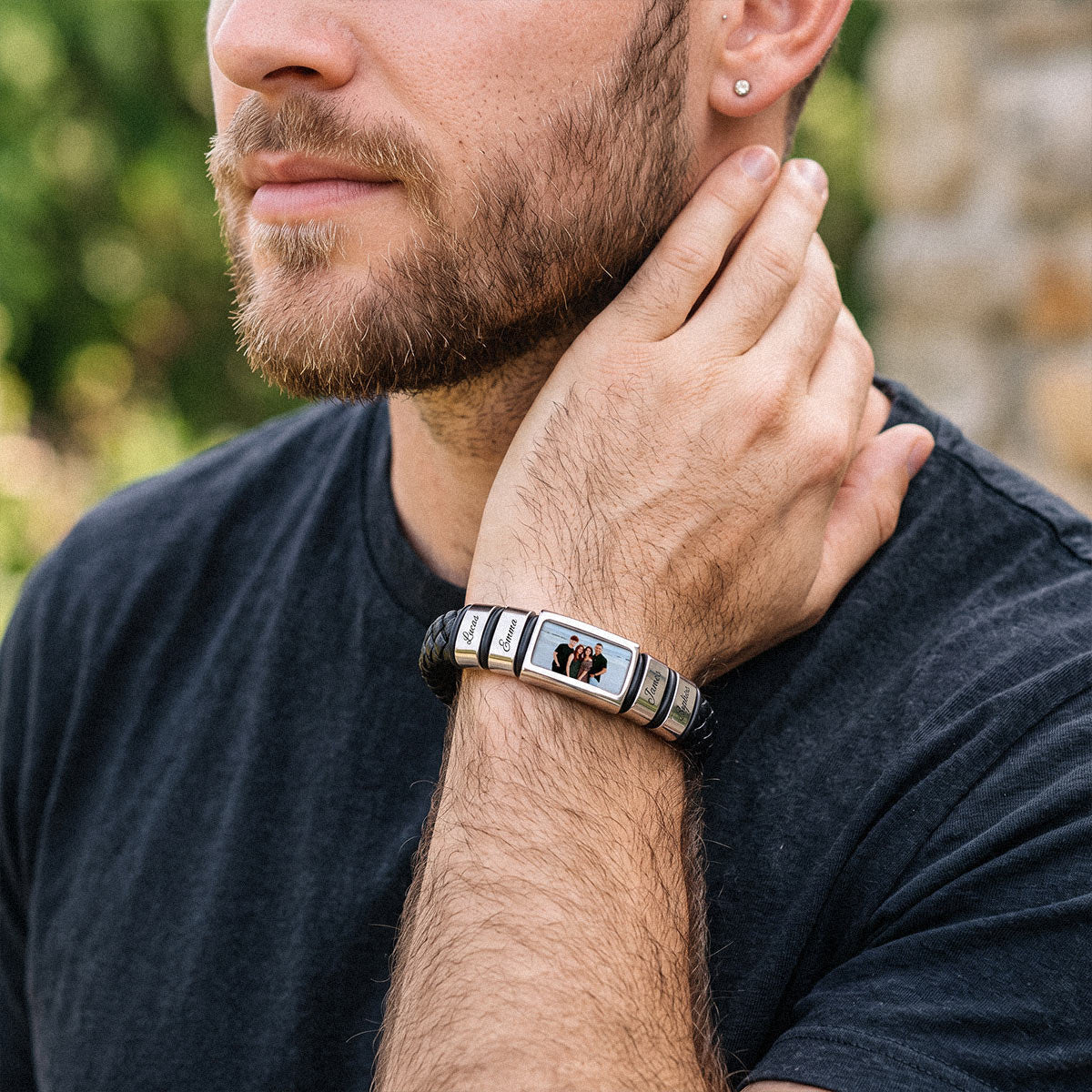 Man wearing personalized multi name engraved braided leather bracelet on wrist