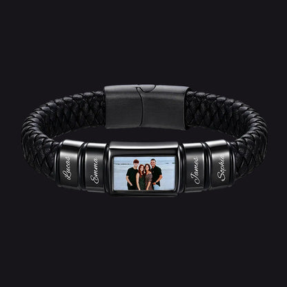 A personalized black braided leather and metal bracelet featuring a central rectangular photo frame and four engraved name beads shown on a plain white background.