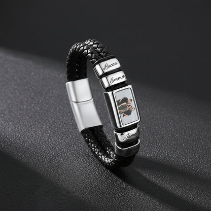 A personalized black braided leather bracelet with silver-tone metal charms. 