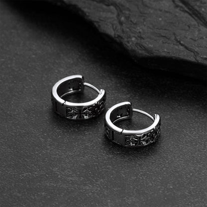 Pair of silver hoop earrings on a dark textured surface