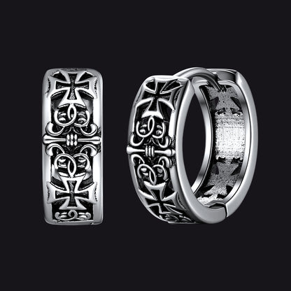 Silver hoop earrings with cross designs on a black background