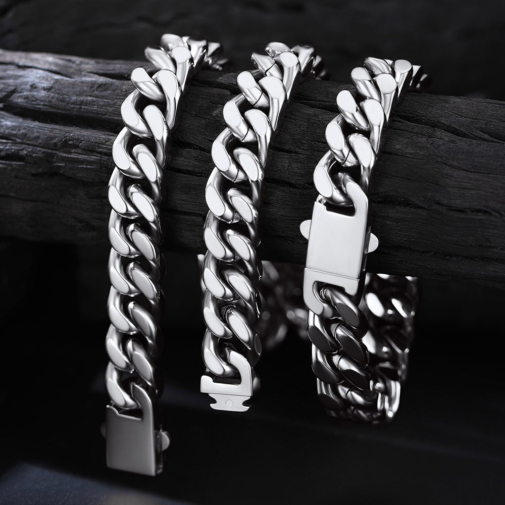 Three silver chain bracelets on a dark wooden surface