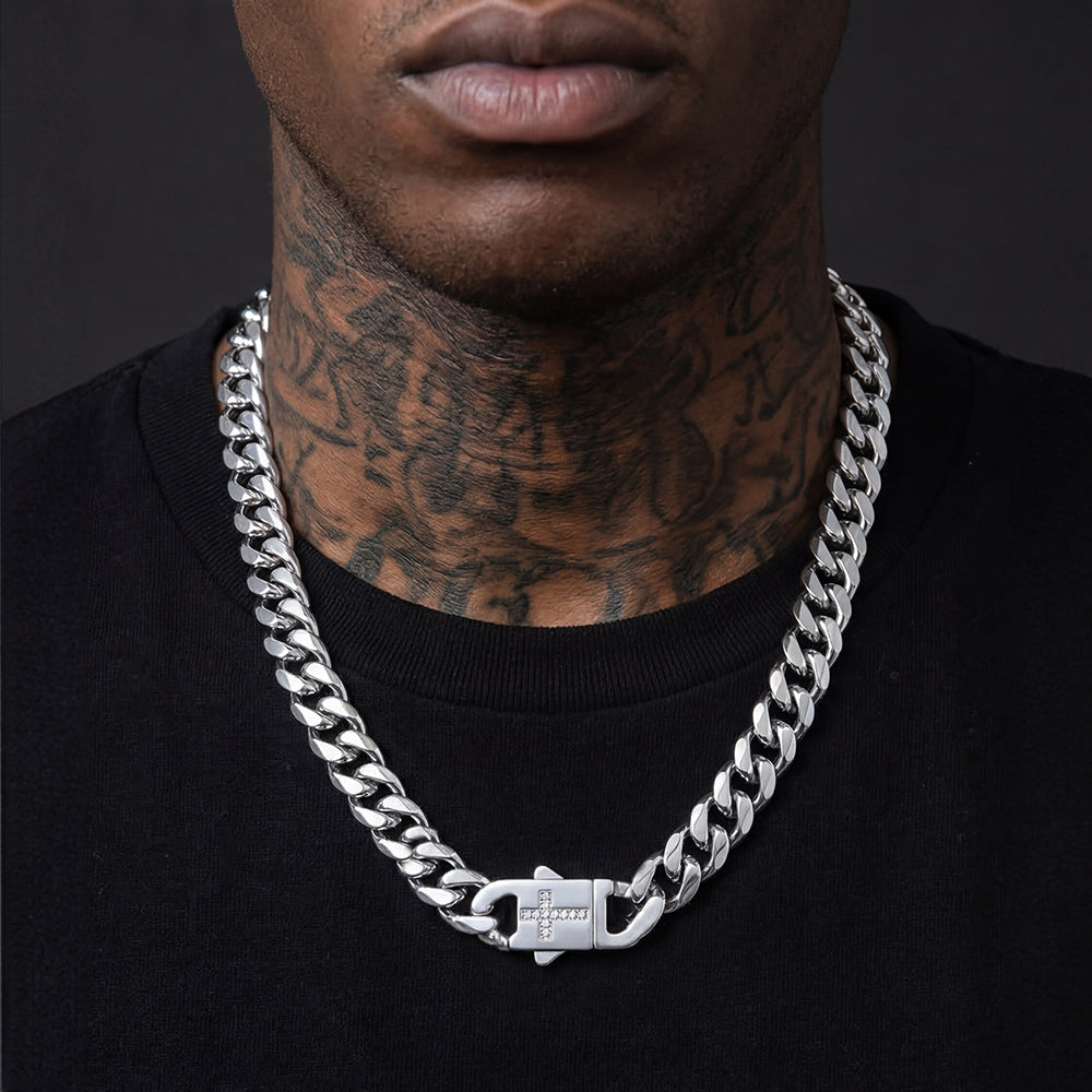 Man wearing a silver chain necklace with a dark background