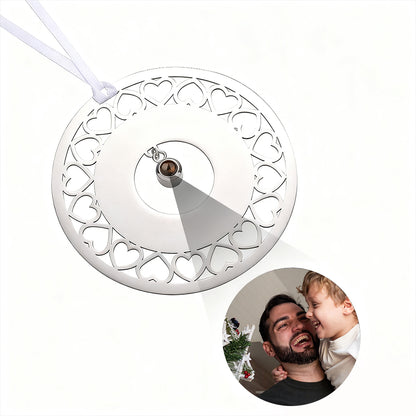 Decorative circular ornament with heart patterns and a small round photo of a man and child on a white background.