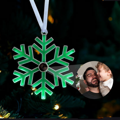 Green snowflake ornament with a blurred inset of a man and child on a dark background