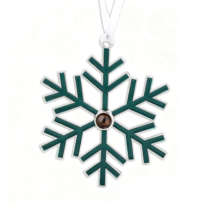 Green snowflake-shaped ornament with a brown center on a white background