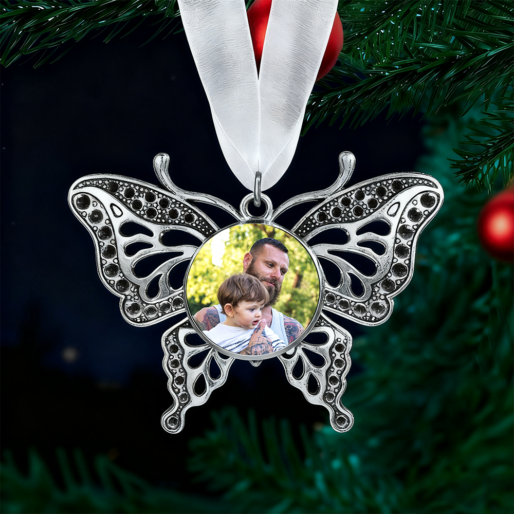 Butterfly-shaped ornament with a photo of a man and child on a green Christmas tree background