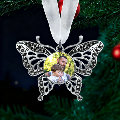 Butterfly-shaped ornament with a photo of a man and child on a green Christmas tree background