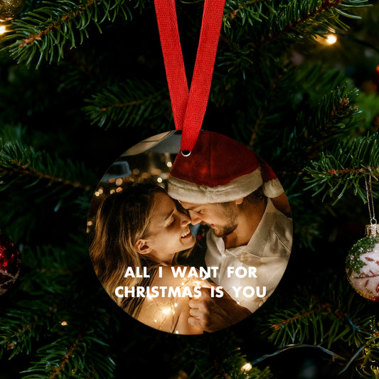 Circular photo ornament with a couple in Santa hats on a Christmas tree, featuring the text 'All I want for Christmas is you'.img