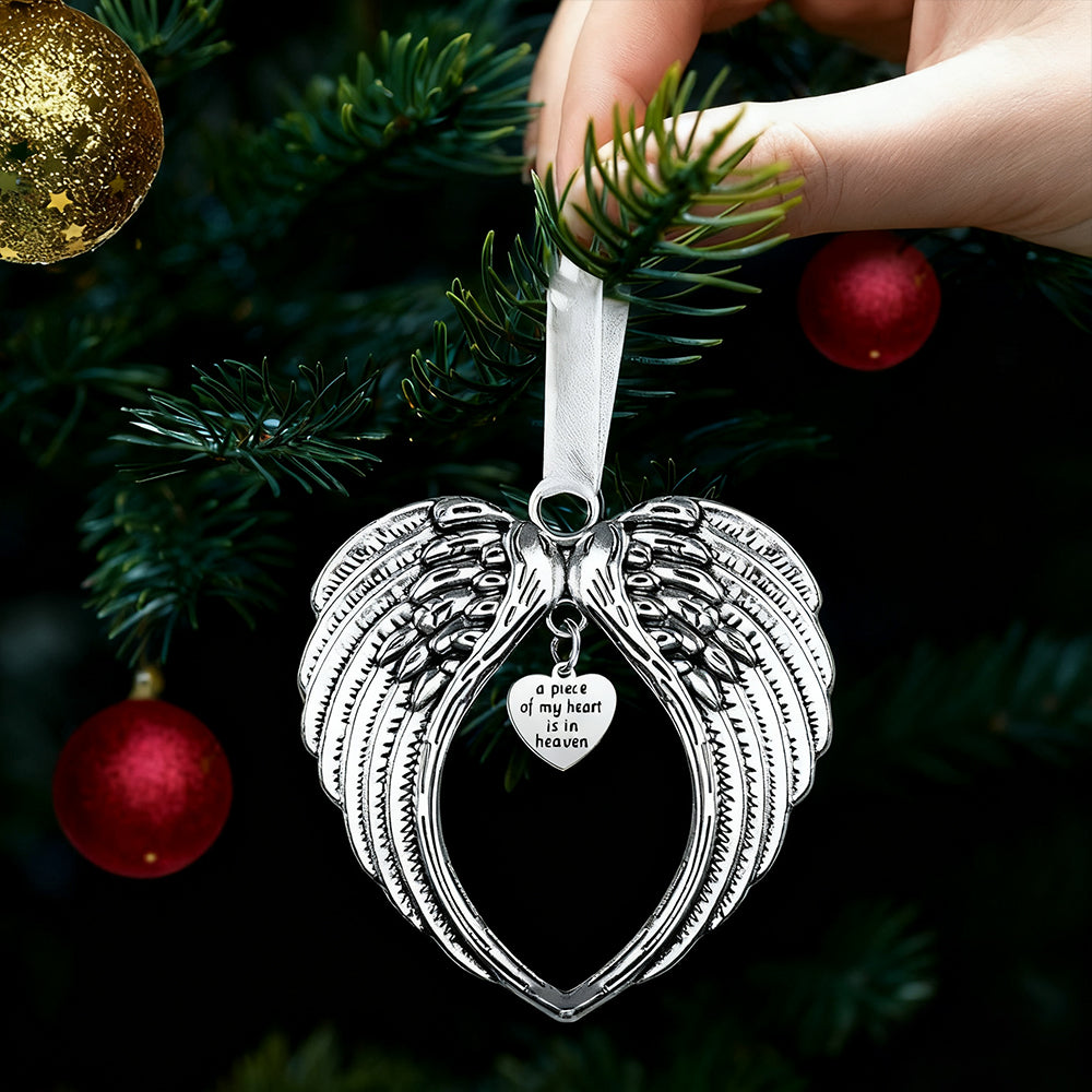 Silver angel wing ornament with heart detail on a Christmas tree.