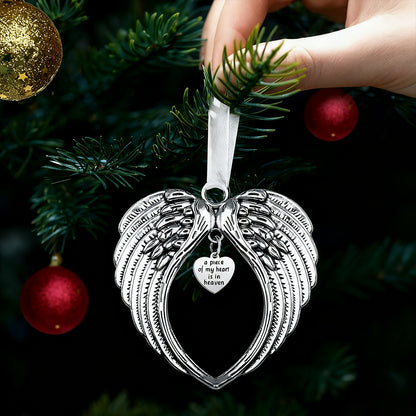 Silver angel wing ornament with heart detail on a Christmas tree.