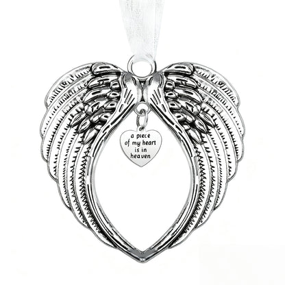Silver angel wing pendant with heart-shaped tag on a white background