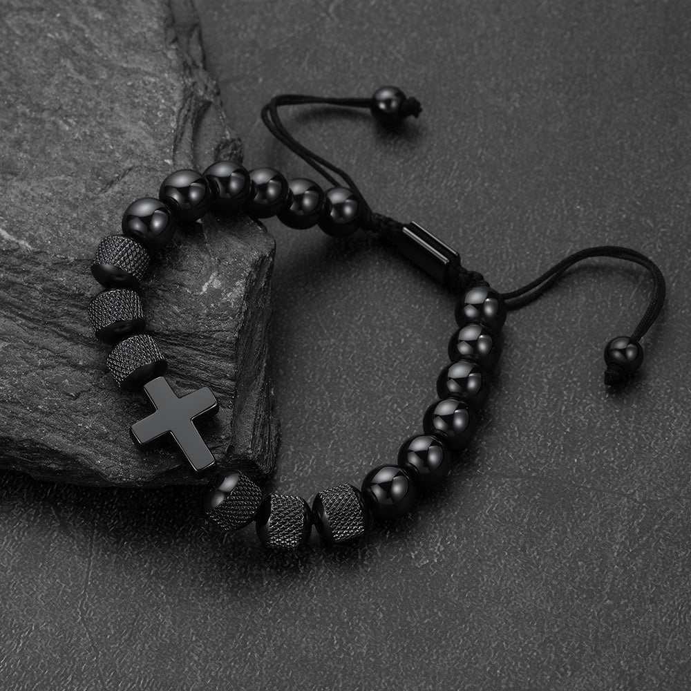 A black beaded bracelet with a cross charm