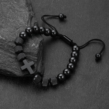 A black beaded bracelet with a cross charm