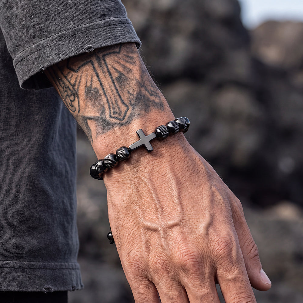 Man wearing black cross obsidian beads bracelet, front wrist view